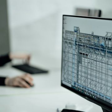 Poste de travail d'un bureau d'études avec la maquette numérique d'un bâtiment à l'écran