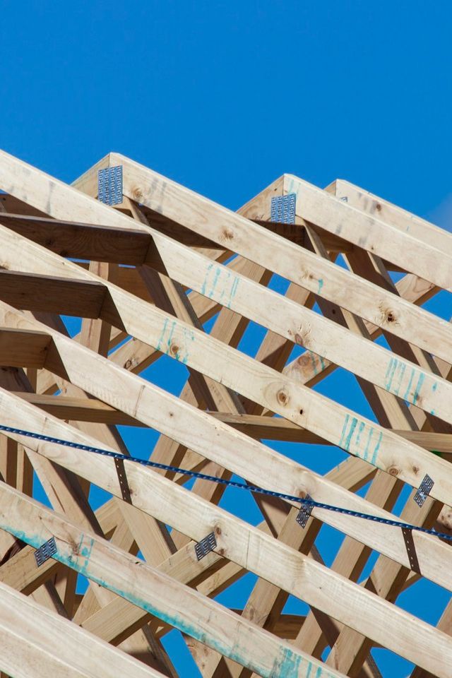 Charpente en bois d'une maison en construction sur fond de ciel bleu